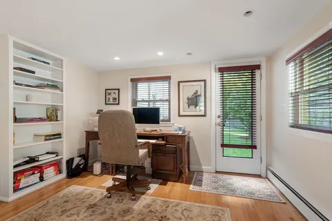 a view of a workspace with furniture and a window