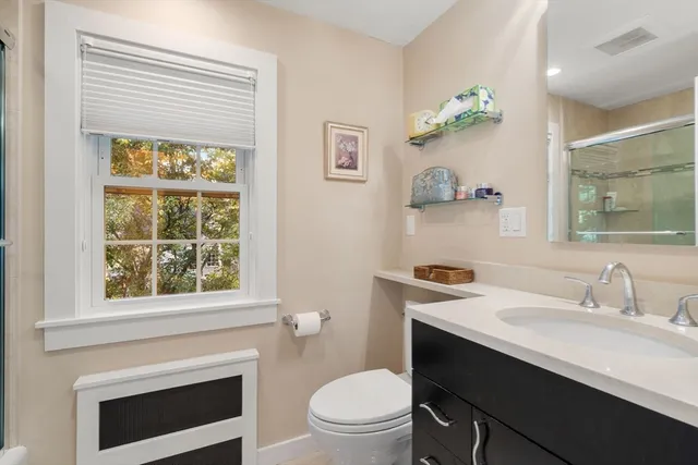 a bathroom with a sink a toilet and a window