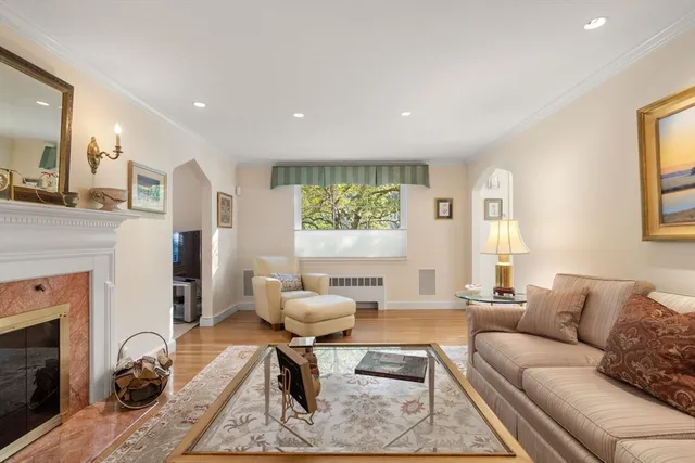 a living room with furniture a fireplace and a window