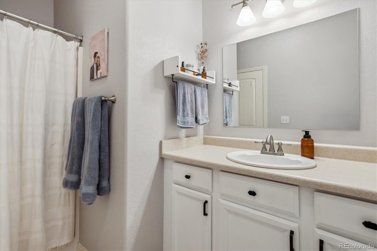 645 Yuma Loop, Unit 103 Kiowa, CO 80117 - Photo 15 of 23 a bathroom with a sink and a mirror