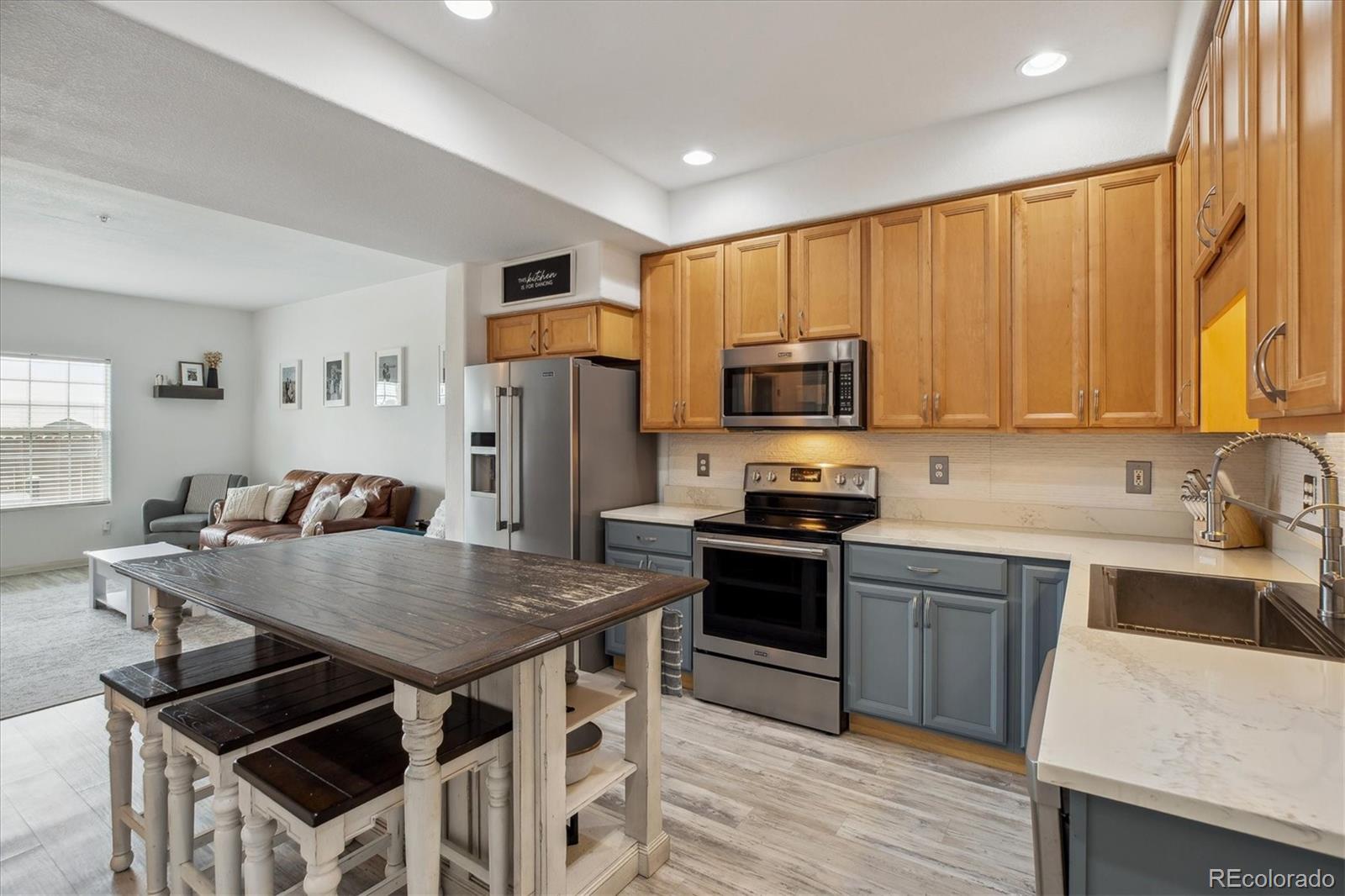 645 Yuma Loop, Unit 103 Kiowa, CO 80117 - Photo 10 of 23 a kitchen with stainless steel appliances granite countertop a stove a sink a microwave refrigerator and chairs