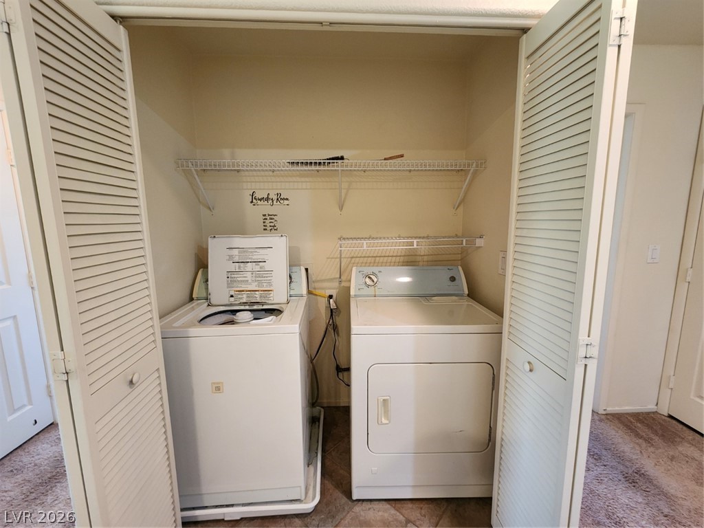 9132 Ripple Ridge Avenue, Unit 102 Las Vegas, NV 89149 - Photo 28 of 42 Laundry area with light carpet and washer and clothes dryer