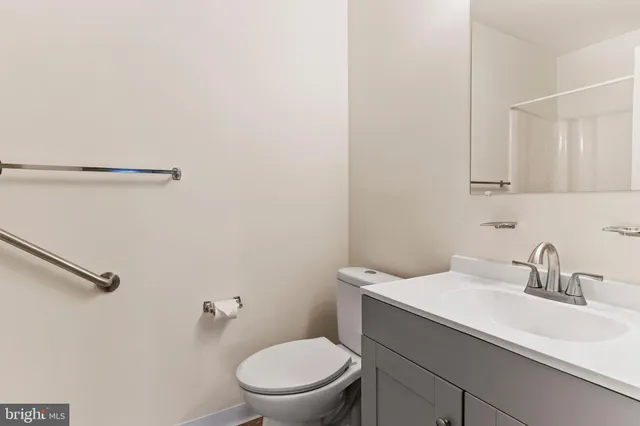 a bathroom with a sink a toilet and a mirror