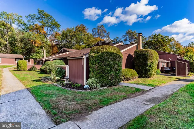 a front view of a house with a yard and potted plants