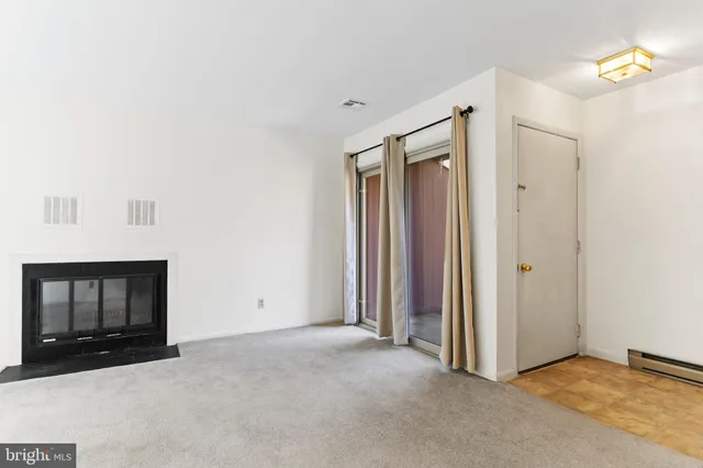 a view of an empty room with closet and a fireplace