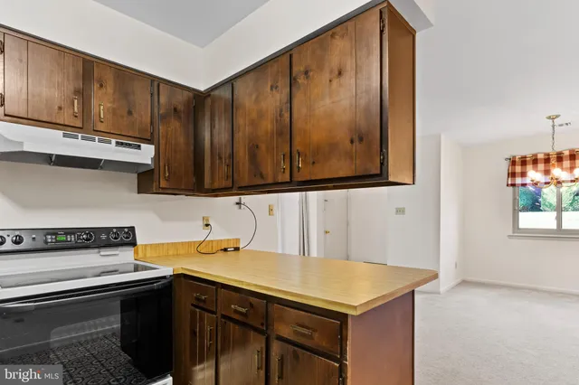 a utility room with stainless steel appliances wooden cabinets and a stove top oven
