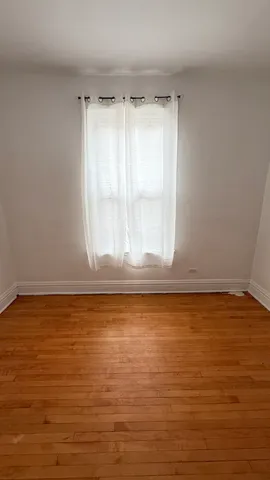 a view of a room with wooden floor and window