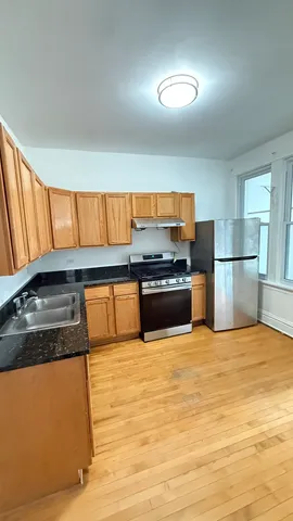 a kitchen with stainless steel appliances granite countertop a refrigerator a stove and a sink