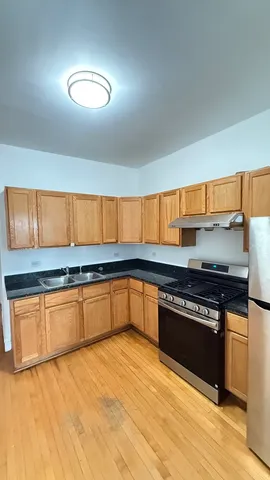 a kitchen with stainless steel appliances granite countertop a stove a sink and a refrigerator