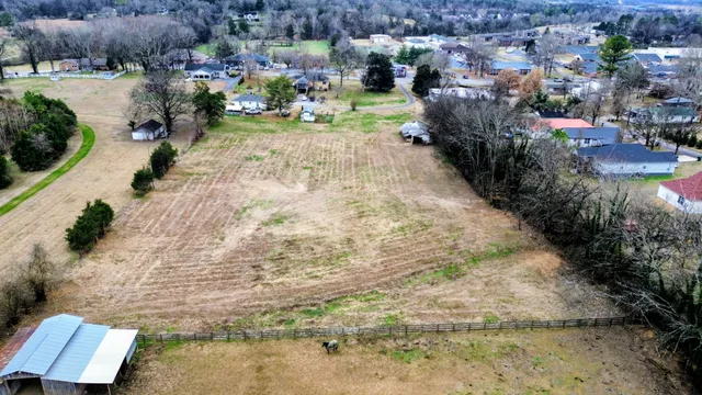 a view of a wooden house with large trees