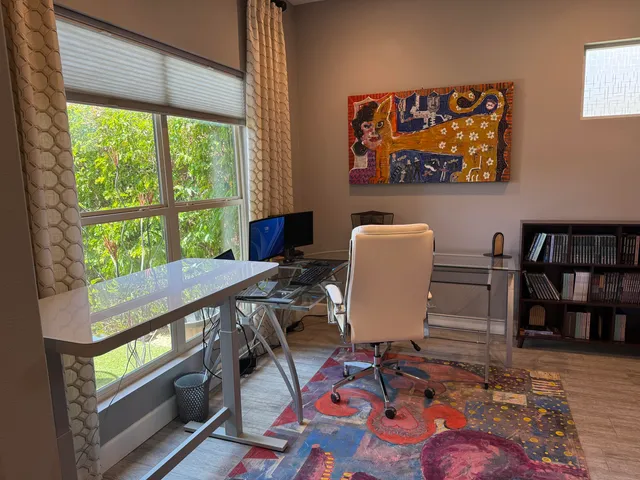 a view of a workspace with furniture and a book shelf