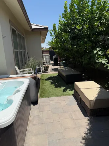 a view of a patio with a dining table and chairs and potted plants