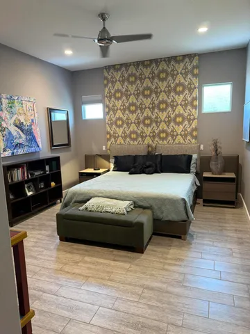 a bedroom with a bed and wooden floor