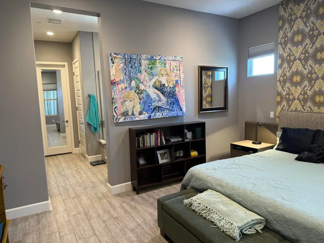 a bedroom with a bed and dresser with mirror