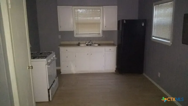 a utility room with cabinets washer and dryer