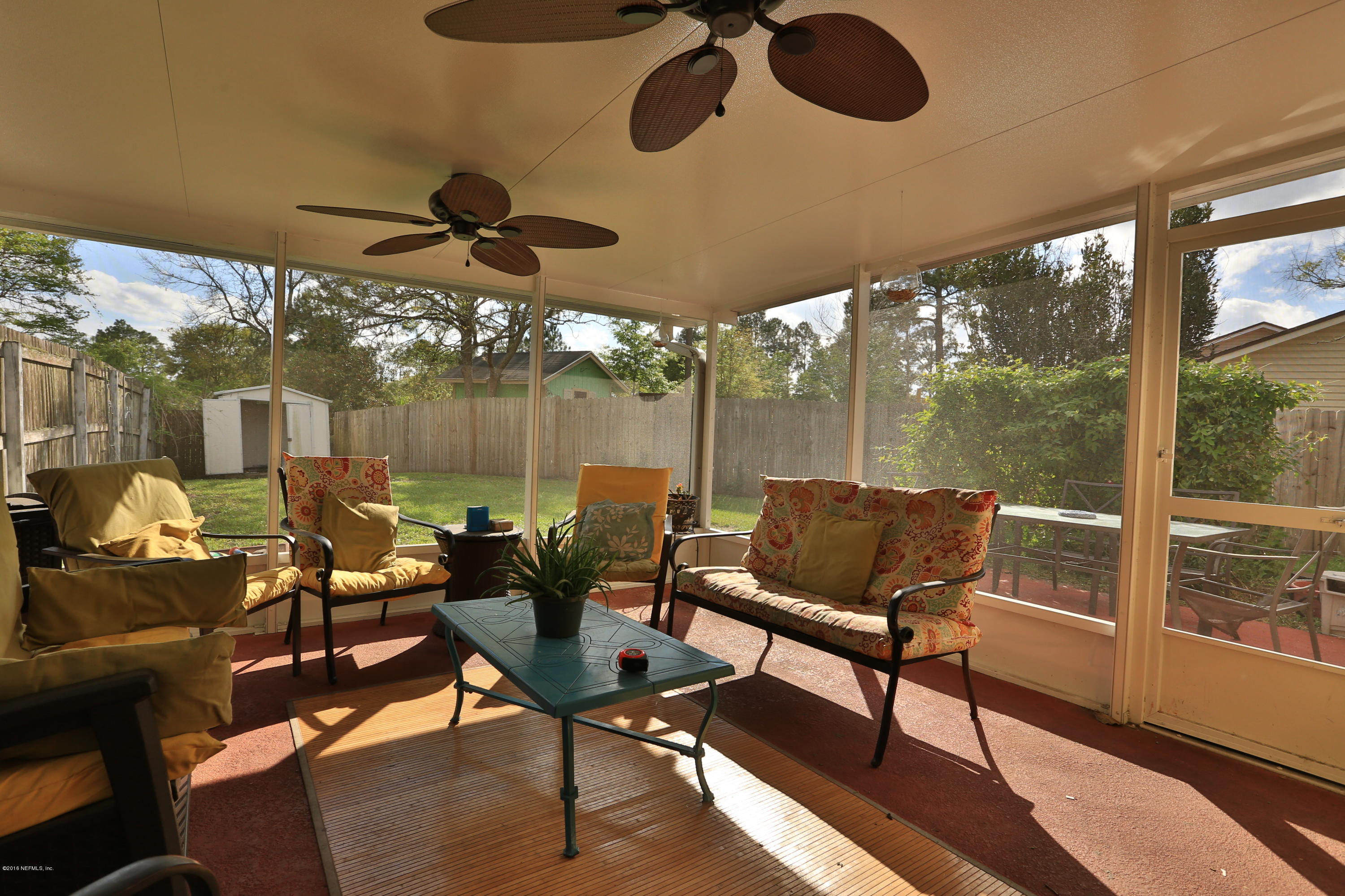 11784 Wattle Tree Road East Jacksonville, FL 32246 - Photo 7 of 24 a living room with patio furniture and a floor to ceiling window