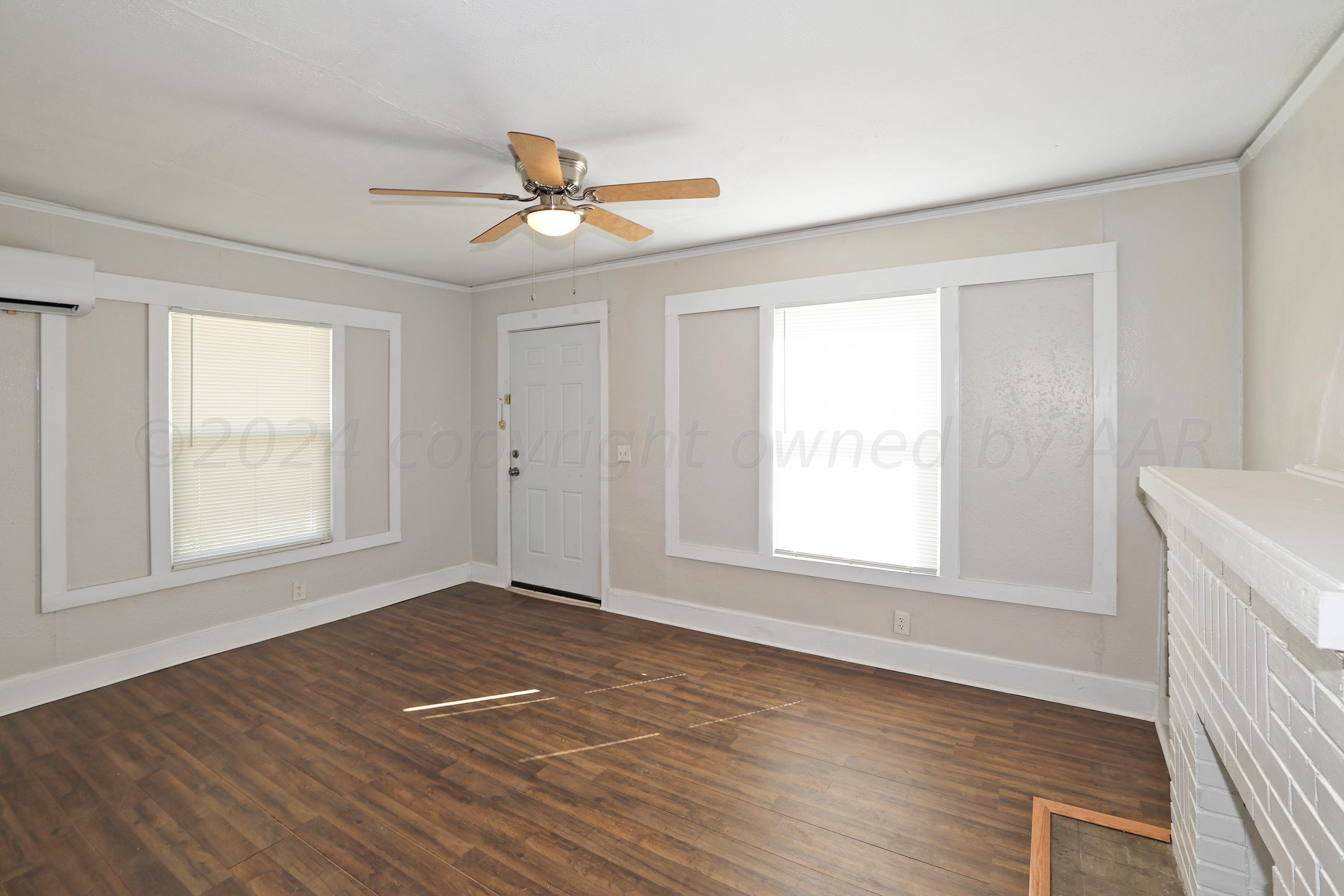 1506 Southwest 11th Avenue Amarillo, TX 79101 - Photo 3 of 10 an empty room with wooden floor fan and windows