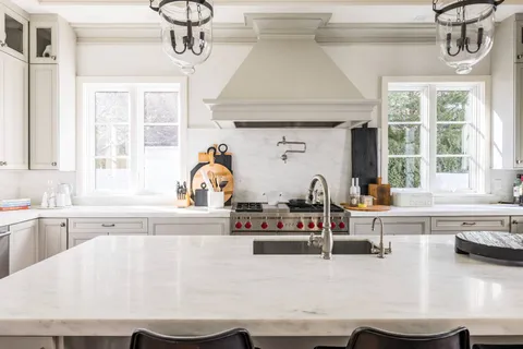 a kitchen with a sink a stove and cabinets