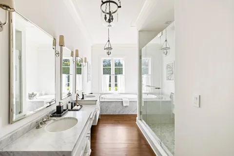 a bathroom with a granite countertop sink a mirror and a bathtub