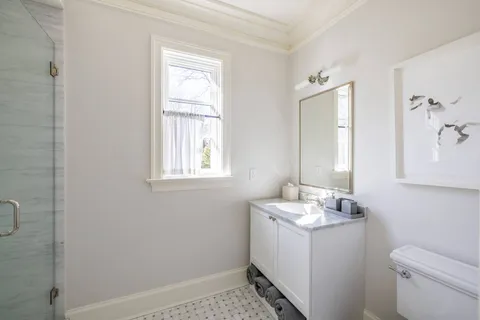 a bathroom with a sink toilet and window