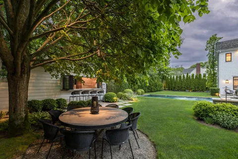 a backyard of a house with table and chairs