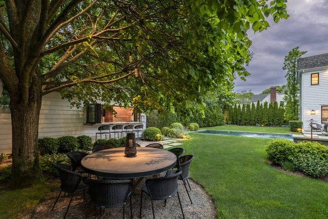 a backyard of a house with table and chairs