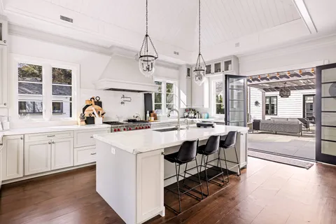 a open kitchen with stainless steel appliances kitchen island granite countertop a sink cabinets and wooden floor