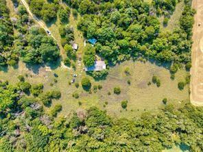 6630 Prather Road Springtown, TX 76082 - Photo 19 of 20 Wooded acreage featuring a single-story residence with a light-toned roof, an additional outbuilding, and expansive cleared areas