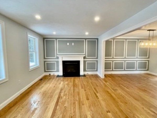 39 Staples Street Billerica, MA 01821 - Photo 12 of 25 a view of empty room with wooden floor and fireplace