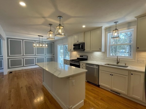 39 Staples Street Billerica, MA 01821 - Photo 6 of 25 a kitchen with stainless steel appliances granite countertop a sink stove and wooden cabinets