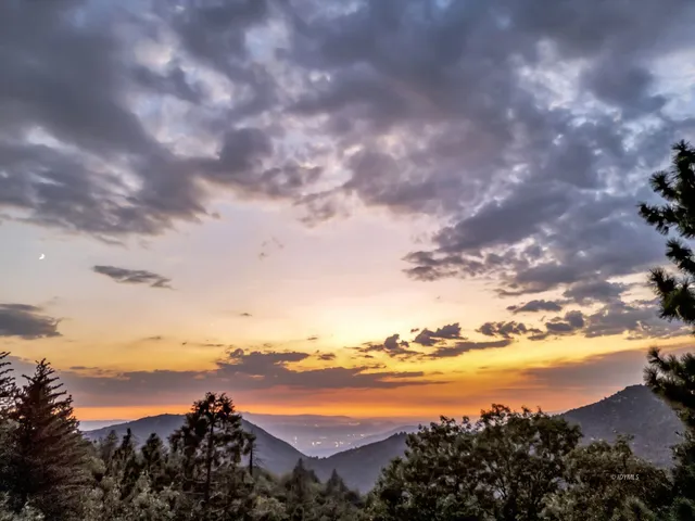 a living room with furniture a large window and wooden floor