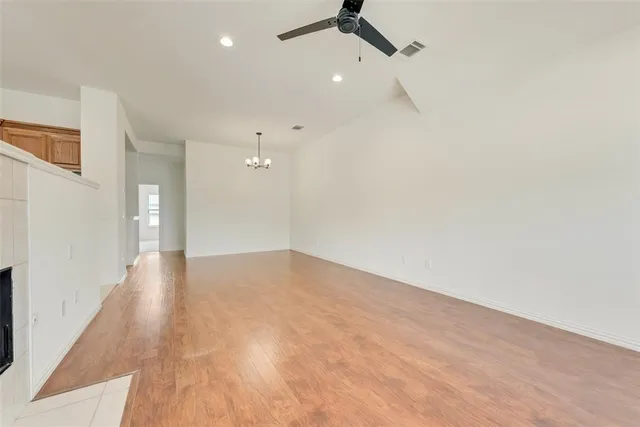 a view of a room with a ceiling fan and wooden floor