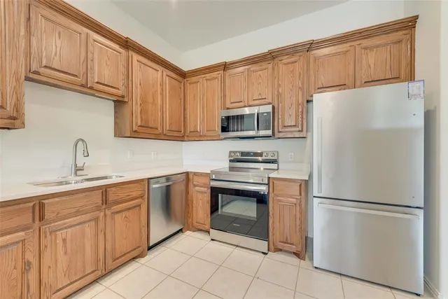 a kitchen with kitchen island granite countertop appliances cabinets and a sink