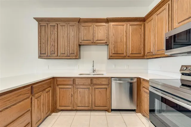 a kitchen with cabinets stainless steel appliances and a sink