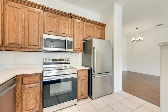 a kitchen with stainless steel appliances granite countertop a sink and dishwasher a stove top oven with wooden floor