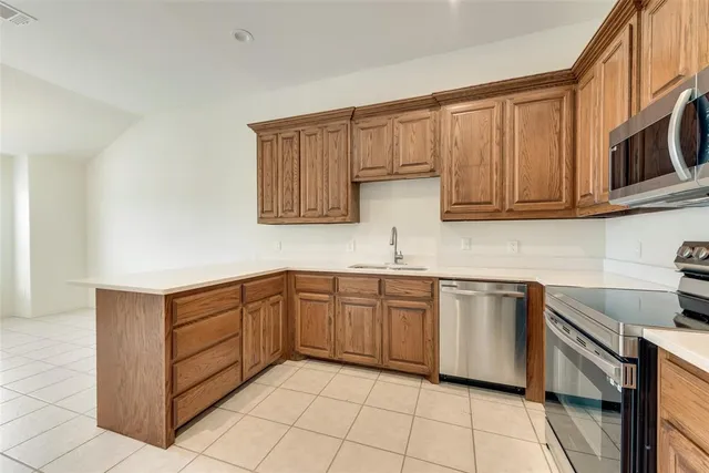 a kitchen with granite countertop a refrigerator stove and microwave