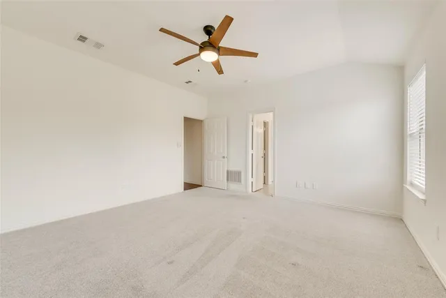 an empty room with closet and windows