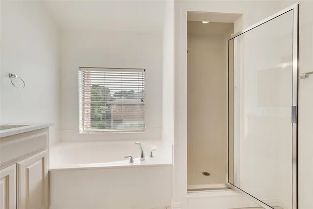 a spacious bathroom with a shower a sink and a mirror