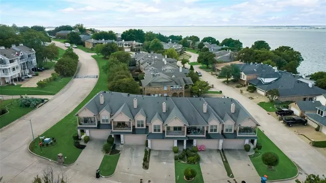 a view of a brick house next to a yard with plants and a big yard