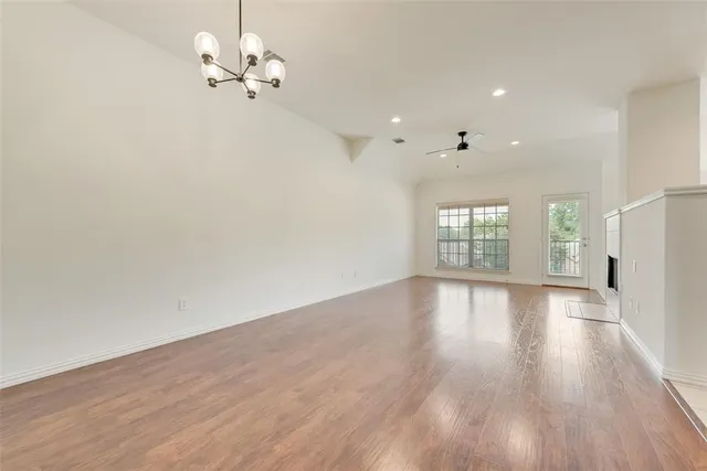 a view of a room with wooden floor and a ceiling fan