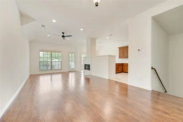 a view of empty room with wooden floor and fireplace