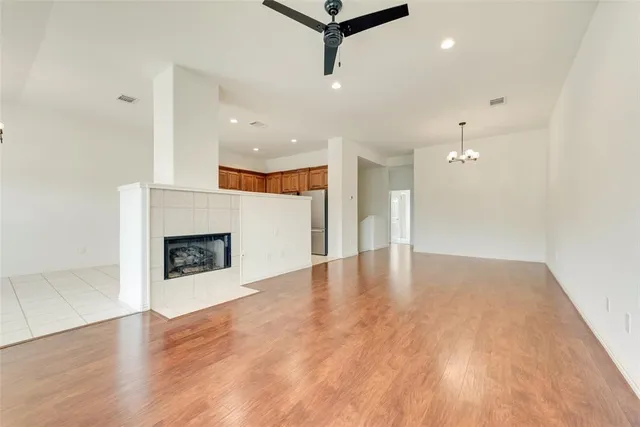 an empty room with wooden floor and fireplace