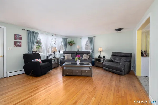 a living room with furniture and a wooden floor
