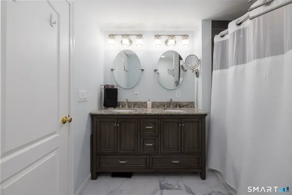 a bathroom with a granite countertop sink a mirror and a shower curtain