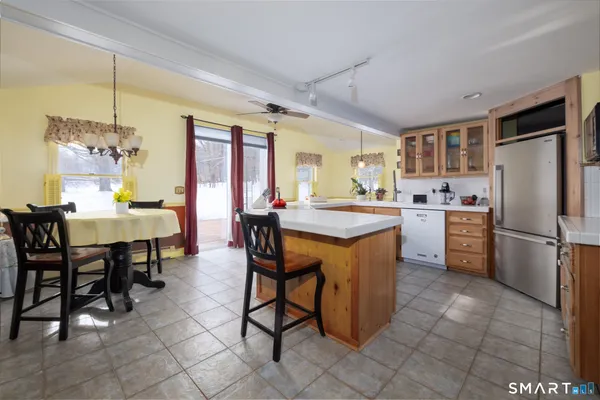 a kitchen with a dining table chairs and refrigerator