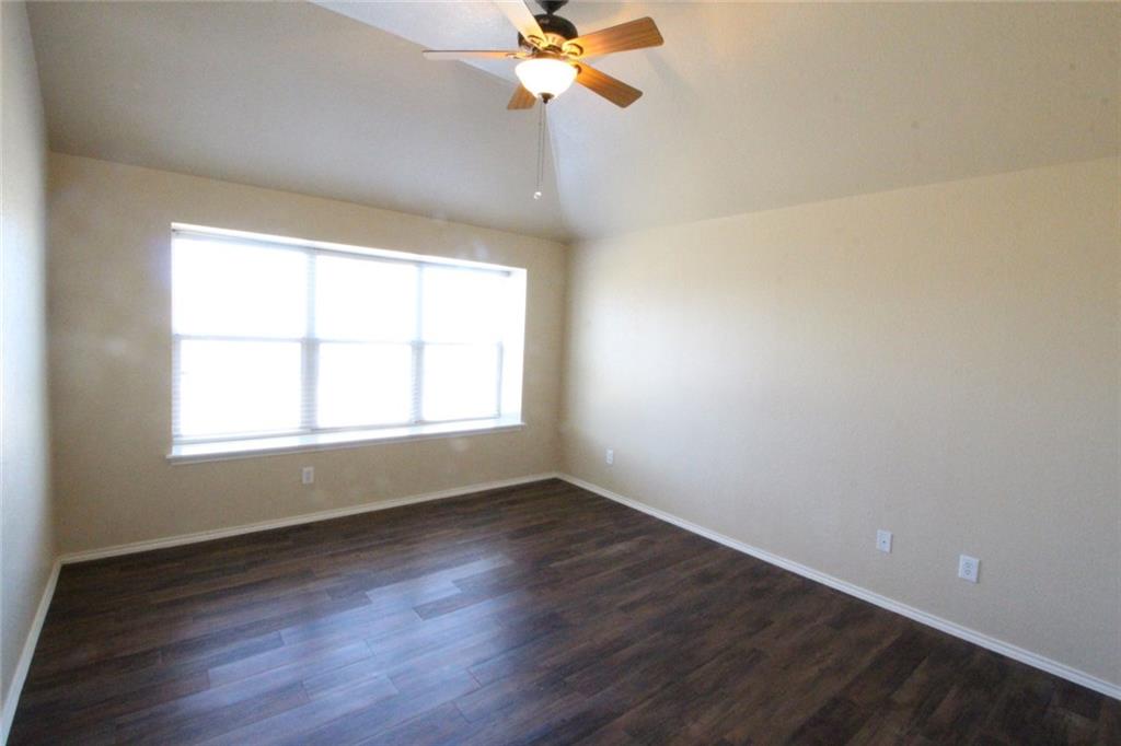 107 Inman Drive Hutto, TX 78634 - Photo 12 of 19 Spacious room featuring vaulted ceilings, wood-finish flooring, and a contemporary ceiling fan