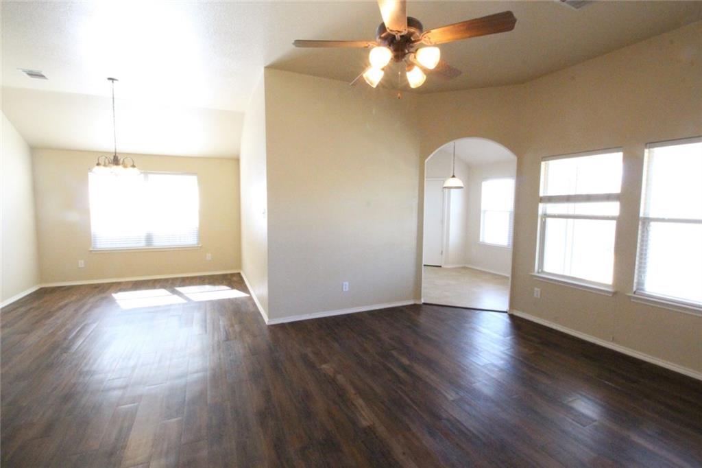 107 Inman Drive Hutto, TX 78634 - Photo 9 of 19 Spacious living area featuring wood-finish flooring, vaulted ceilings, a ceiling fan, and multiple windows