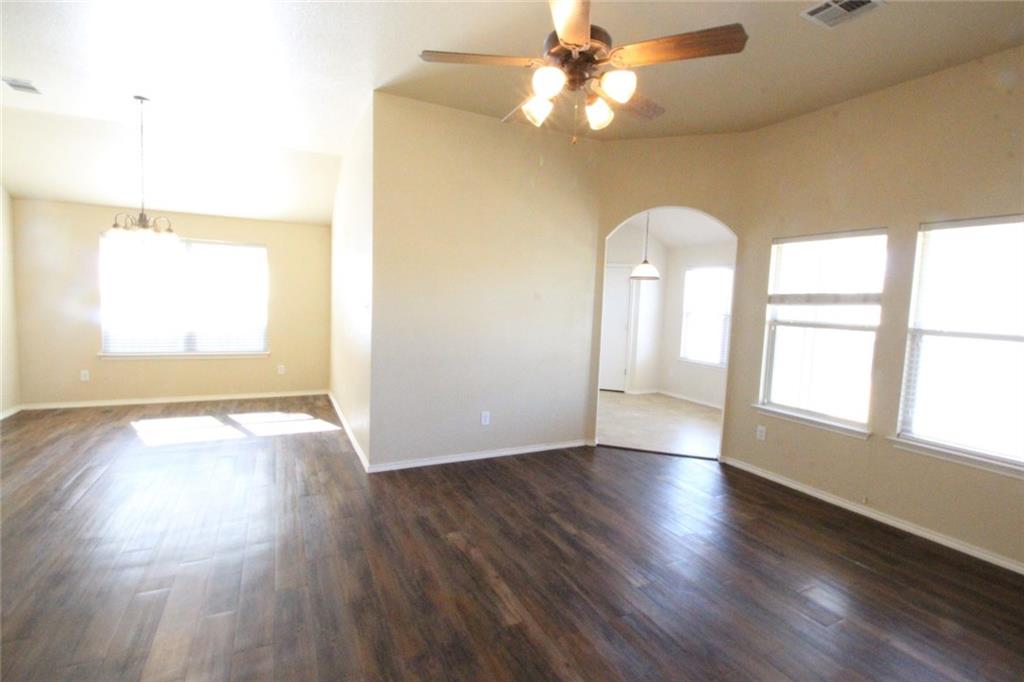 107 Inman Drive Hutto, TX 78634 - Photo 10 of 19 Expansive living area featuring wood-finish flooring, a ceiling fan with light fixture, and multiple windows