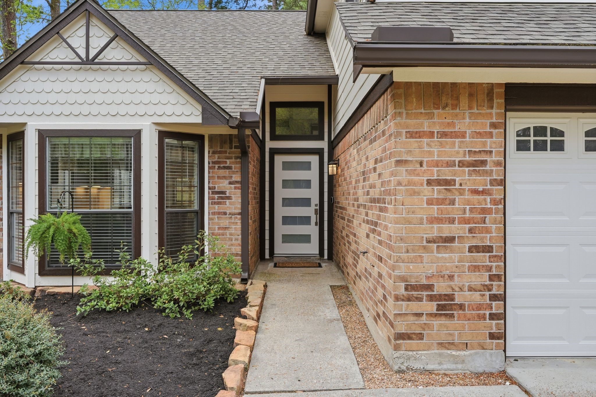 14 Dusky Meadow Place Spring, TX 77381 - Photo 3 of 47 Inviting front entry with modern curb appeal, featuring a sleek contemporary front door with glass inserts and transom window above that brings in natural light.