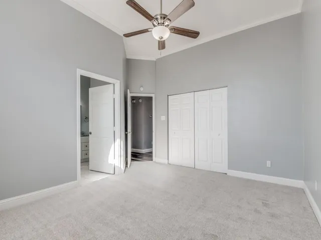 an empty room with closet and a ceiling fan